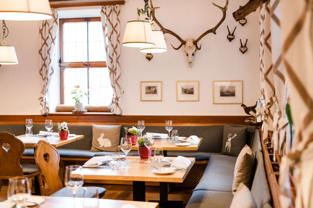 Helles Restaurant mit schnuckeligen Tischen und Geweihen an der Wand